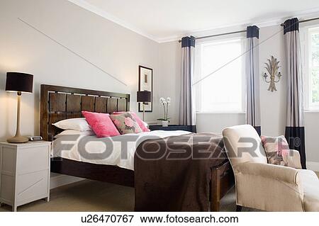 White Bedlinen And Brown Throw On Bed With Wooden Headboard