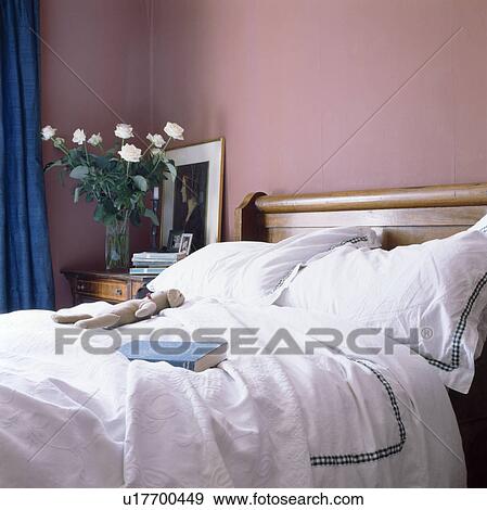 Stock Photo - White bedlinen on bed in pink bedroom. Fotosearch