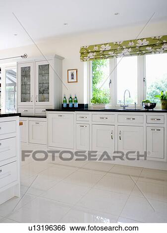 White ceramic flooring in traditional white kitchen with patterend green blind on window above sink View Large Photo Image Stock Photograph - White ceramic flooring in traditional white kitchen with patterend green blind on window above sink. Fotosearch