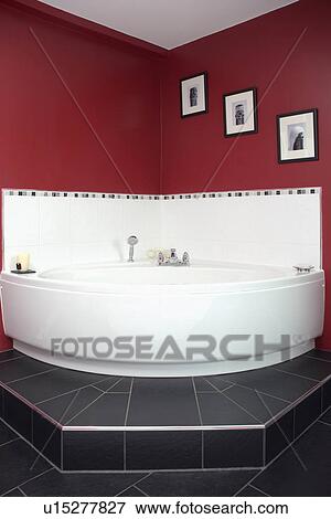Stock Photo - White corner bath in red bathroom. Fotosearch