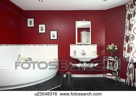 Stock Photograph - White corner bath in red bathroom . Fotosearch
