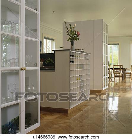 White cupboard with glazed doors in modern white kitchen with wooden flooring View Large Photo Image Stock Photography - White cupboard with glazed doors in modern white kitchen with wooden flooring. Fotosearch