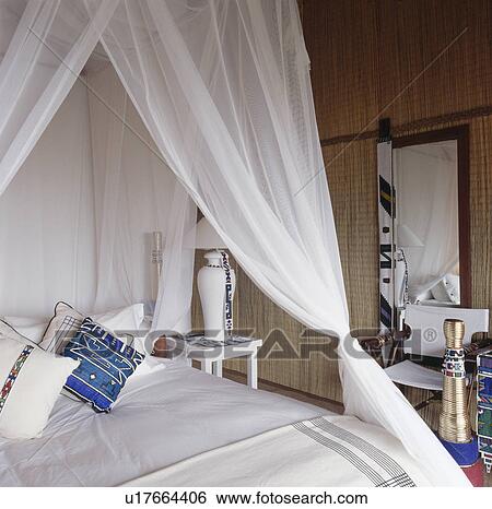 White drapes on bed with white linen in cream bedroom View Large Photo Image Stock Photograph - White drapes on bed with white linen in cream bedroom. Fotosearch