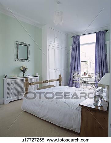 White Duvet On Bed In Pastel Green Bedroom With Fretwork Radiator