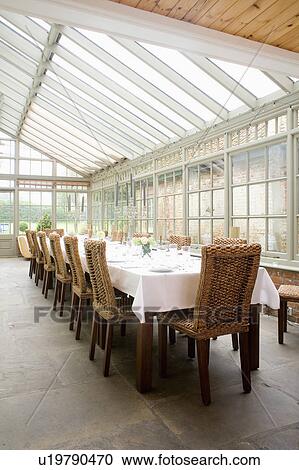 White linen cloth on table in conservatory dining room with wicker and wood dining chairs and flagstone floor View Large Photo Image Stock Image - White linen cloth on table in conservatory dining room with wicker and wood dining chairs and flagstone floor. Fotosearch