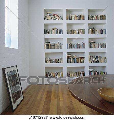 White recessed bookshelves in modern white dining room View Large Photo Image Stock Photo - White recessed bookshelves in modern white dining room. Fotosearch