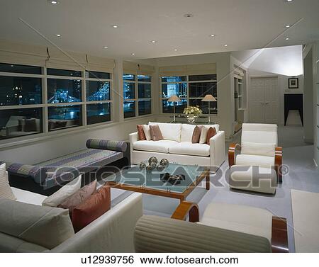 White sofas and grey chaiselongue in living room in modern city apartment at night View Large Photo Image Stock Photograph - White sofas and grey chaiselongue in living room in modern city apartment at night. Fotosearch