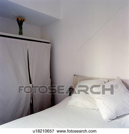 White tented storage beside bed with white linen in white bedroom View Large Photo Image Stock Photo - White tented storage beside bed with white linen in white bedroom. Fotosearch