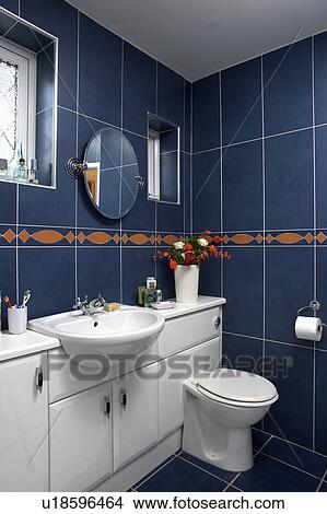 Picture - White vanity unit with fitted basin and toilet in black tiled bathroom. Fotosearch