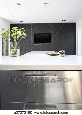 Stock Image - White worktop on stainless steel unit in modern black and white kitchen. Fotosearch