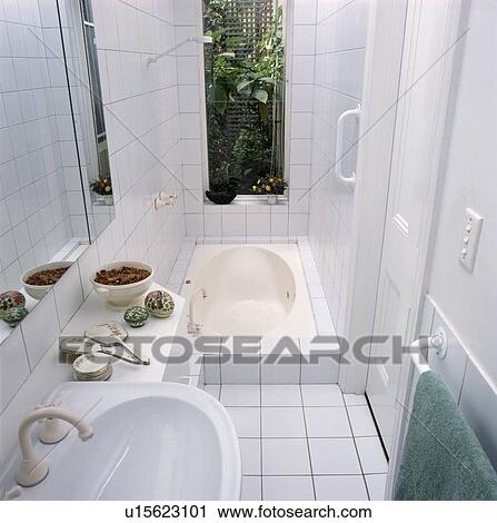 Window above sunken bath in small white tiled bathroom View Large Photo Image Stock Image - Window above sunken bath in small white tiled bathroom. Fotosearch