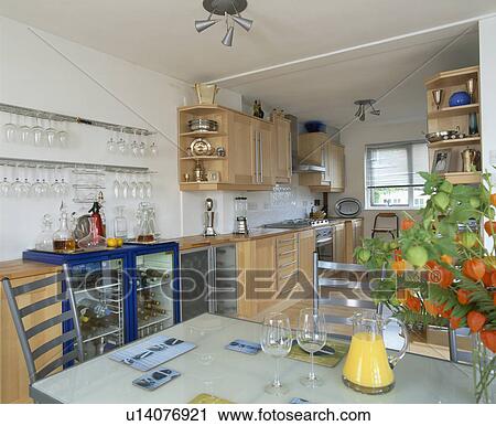 Wine cooler with glazed doors in modern kitchen with glass-topped table and pale wood fitted cupboards View Large Photo Image Stock Image - Wine cooler with glazed doors in modern kitchen with glass-topped table and pale wood fitted cupboards. Fotosearch