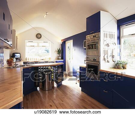 Stock Photo - Wlooden flooring in modern blue and white kitchen. Fotosearch