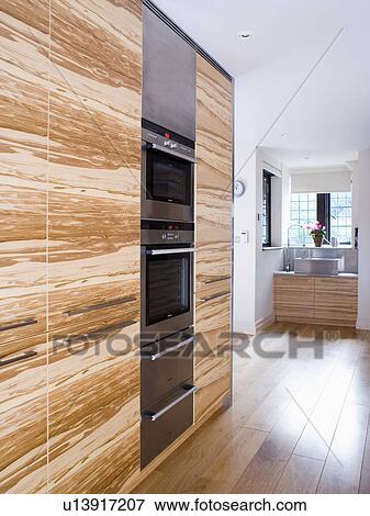 Wood veneer units with fitted double oven in modern kitchen View Large Photo Image Stock Photo - Wood veneer units with fitted double oven in modern kitchen. Fotosearch