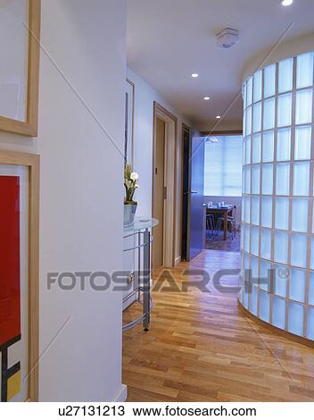 Stock Image - Wooden flooring in modern hall with curved glass brick wall. Fotosearch