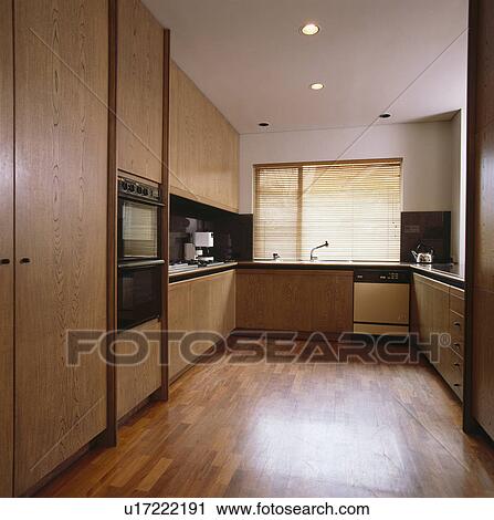 Stock Image - Wooden flooring in modern neutral kitchen. Fotosearch
