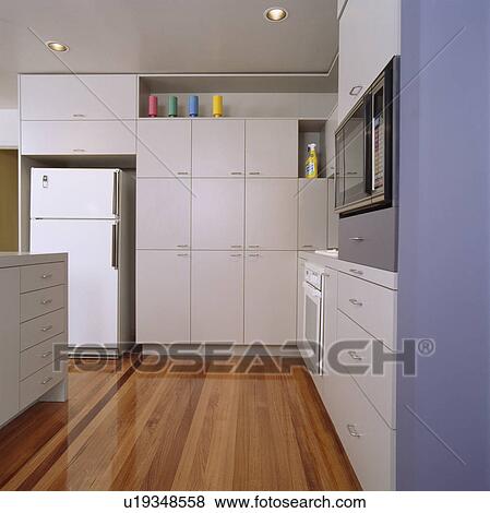 Stock Photo - Wooden flooring in modern white kitchen. Fotosearch