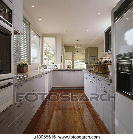 Wooden flooring in modern white kitchen View Large Photo Image Stock Photograph - Wooden flooring in modern white kitchen. Fotosearch