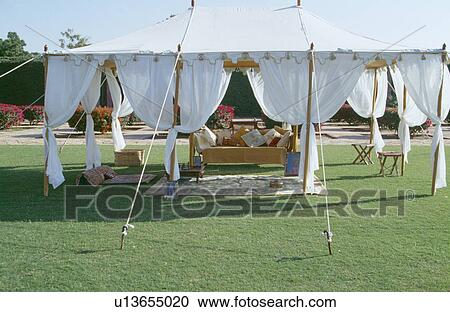 Wooden settle piled with cushions in traditional white Rajastani tent with white drapes View Large Photo Image Stock Image - Wooden settle piled with cushions in traditional white Rajastani tent with white drapes. Fotosearch