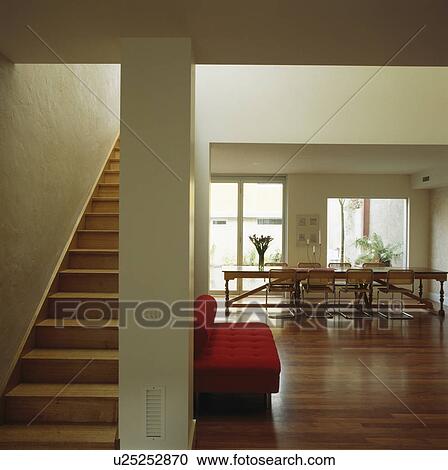 Stock Image - Wooden staircase and flooring in large openplan modern white hall. Fotosearch