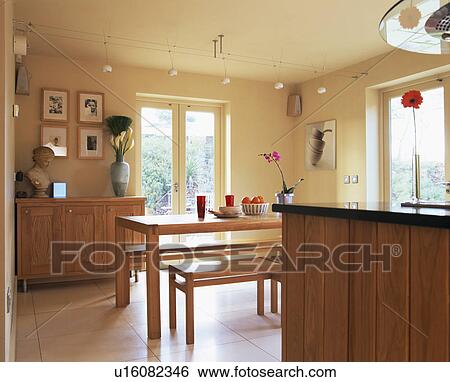 Stock Photograph - Wooden table and benches in modern kitchen dining room. Fotosearch
