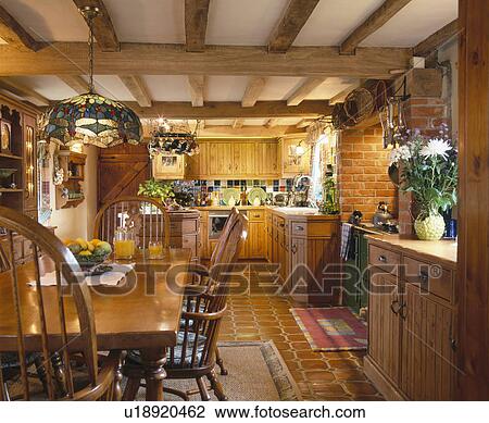 Wooden table and chairs in beamed country kitchen dining room with fitted pine cupboards View Large Photo Image Stock Image - Wooden table and chairs in beamed country kitchen dining room with fitted pine cupboards. Fotosearch