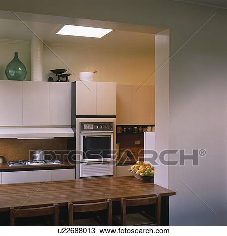 Wooden table and chairs in modern white kitchen View Large Photo Image Stock Image - Wooden table and chairs in modern white kitchen. Fotosearch