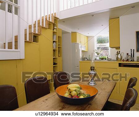Wooden table in modern yellow kitchen dining room View Large Photo Image Picture - Wooden table in modern yellow kitchen dining room. Fotosearch