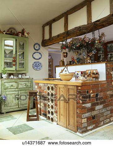 Wooden worktop on brick islancd unit in country kitchen with green wall-cupboard and distressed green chest-of-drawers View Large Photo Image Stock Photo - Wooden worktop on brick islancd unit in country kitchen with green wall-cupboard and distressed green chest-of-drawers. Fotosearch