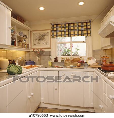 Yellow and grey checked blind in small cream fitted kitchen with downlighting and dishwasher View Large Photo Image Stock Image - Yellow and grey checked blind in small cream fitted kitchen with downlighting and dishwasher. Fotosearch
