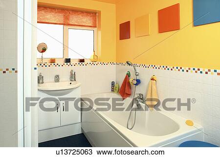 Yellow family bathroom with white tiled wall above bath and basin View Large Photo Image Stock Image - Yellow family bathroom with white tiled wall above bath and basin. Fotosearch