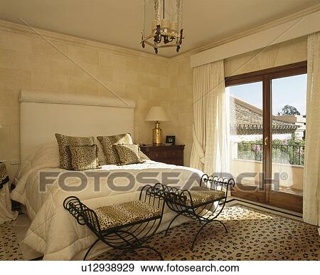 Animalprint cushions and carpet in bedroom with metal stools and patio doors to balcony View Large Photo Image Stock Photo - Animalprint cushions and carpet in bedroom with metal stools and patio doors to balcony. Fotosearch