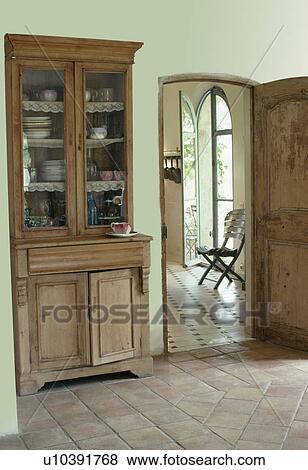 Antique glass-front dresser in French country hall with terracotta floor tiles View Large Photo Image Stock Photo - Antique glass-front dresser in French country hall with terracotta floor tiles. Fotosearch