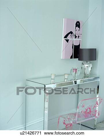Audrey Hepburn picture on turquoise wall above mirrored table with perspex chair View Large Photo Image Stock Image - Audrey Hepburn picture on turquoise wall above mirrored table with perspex chair . Fotosearch