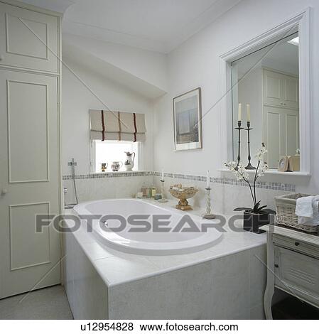 Stock Photo - Bath with white tiled surround in small attic bathroom. Fotosearch