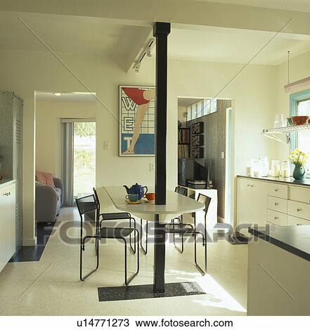 Black metal chairs at fitted table in modern open-plan dining room View Large Photo Image Stock Image - Black metal chairs at fitted table in modern open-plan dining room. Fotosearch