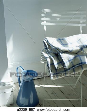 Blue enamel jug beside white chair with pile of blue checked blankets View Large Photo Image Stock Photo - Blue enamel jug beside white chair with pile of blue checked blankets. Fotosearch