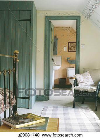 Stock Image - Blue fitted wardrobe and door frame in white traditional bedroom. Fotosearch
