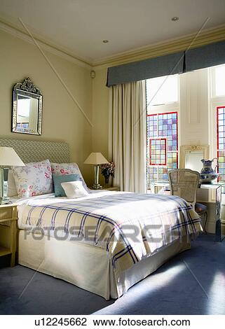 Blue+cream checked throw on bed in traditional bedroom with blue carpet and cream curtains with blue pelmet View Large Photo Image Stock Image - Blue+cream checked throw on bed in traditional bedroom with blue carpet and cream curtains with blue pelmet. Fotosearch
