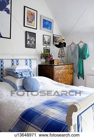 Blue+white checked throw and white linen on upholstered French bed in white country bedroom View Large Photo Image Stock Image - Blue+white checked throw and white linen on upholstered French bed in white country bedroom. Fotosearch
