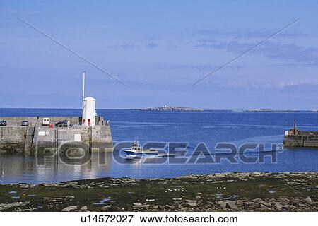 Boat entering the harbour at Seahouses in Northumberland View Large Photo Image Stock Photo - Boat entering the harbour at Seahouses in Northumberland. Fotosearch