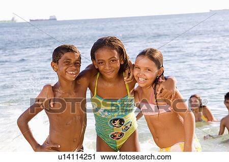 Stock Image - Brazil. Children. Beach. Ocean.. Fotosearch