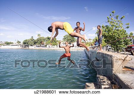 Stock Image - Brazil. Children jumping into water.. Fotosearch