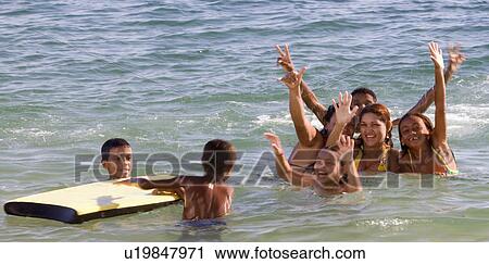 Stock Image - Brazil. Children playing in the water at beach.. Fotosearch