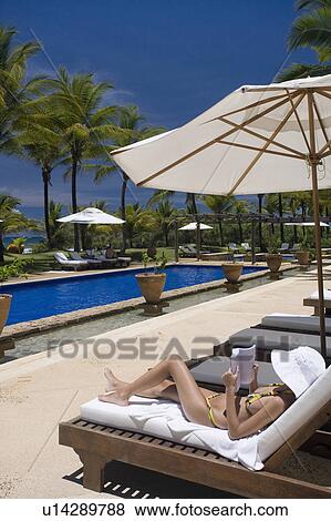 Brazil. Woman reading book. Pool. Chair. Umbrella. View Large Photo Image Stock Photo - Brazil. Woman reading book. Pool. Chair. Umbrella.. Fotosearch