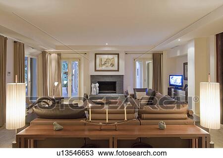 Brown and cream livingroom with full length windows and television. View Large Photo Image Stock Image - Brown and cream livingroom with full length windows and television.. Fotosearch