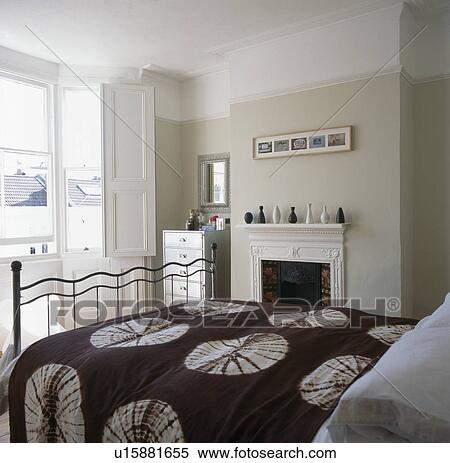 Brown+white patterned bedcover on bed in traditional cream bedroom View Large Photo Image Stock Photography - Brown+white patterned bedcover on bed in traditional cream bedroom. Fotosearch
