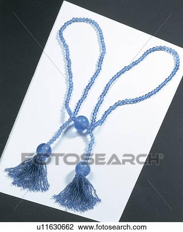 Stock Image - Close-up of blue beaded tieback with beaded tassels. Fotosearch