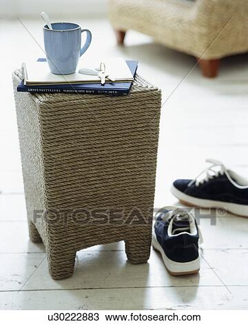 Stock Image - Close-up of blue cup on wicker coffee table. Fotosearch