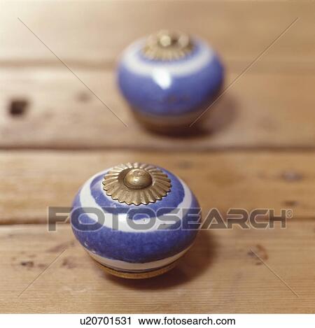 Stock Image - Close up of blue & white ceramic door handles. Fotosearch